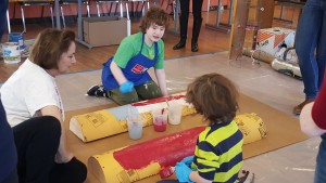 two children kneeling and painting half pipes.
