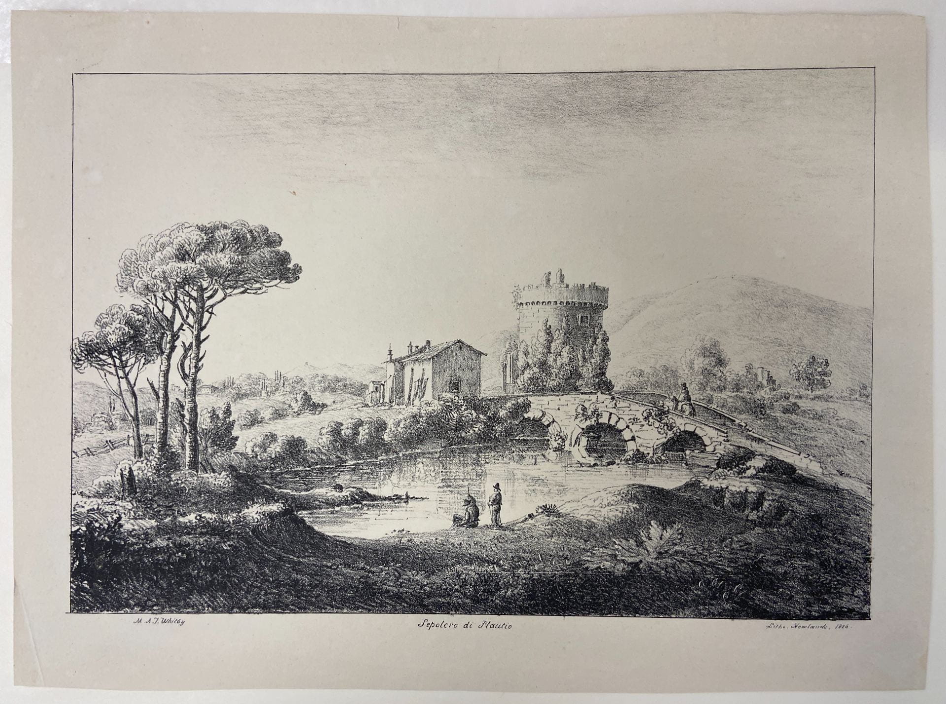 black and white lithograph view of trees on the left, people on a riverbank in the center front, a bridge with one arch on the middle right leading to a crenillated tower and building with peaked roof in the center of the composition, countryside on the middle left, hill behind. 