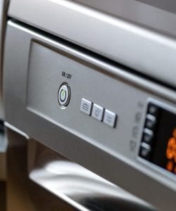 Close up of the on switch of a stainless steel oven or similar appliance.